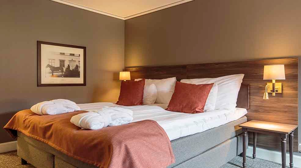 Superior double bed with robes at Clarion Collection Hotel Uman Umeå